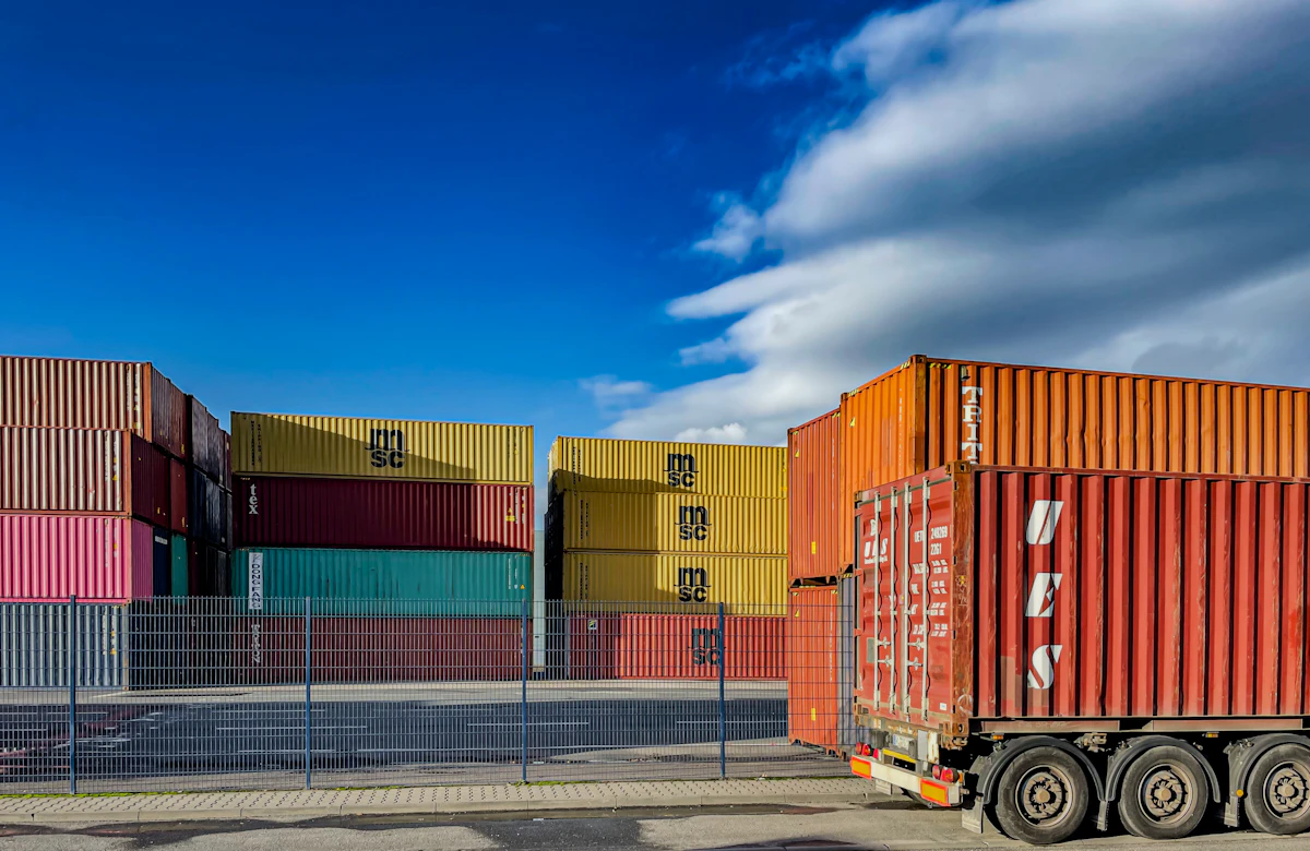 Shipping containers and a loaded container trailer at a European freight terminal